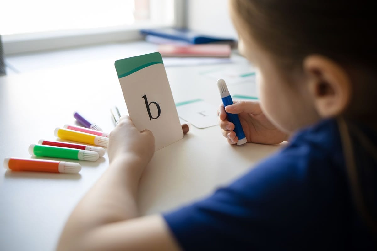 child-learning-letters-with-colorful-markers child learning letters with colourful markers