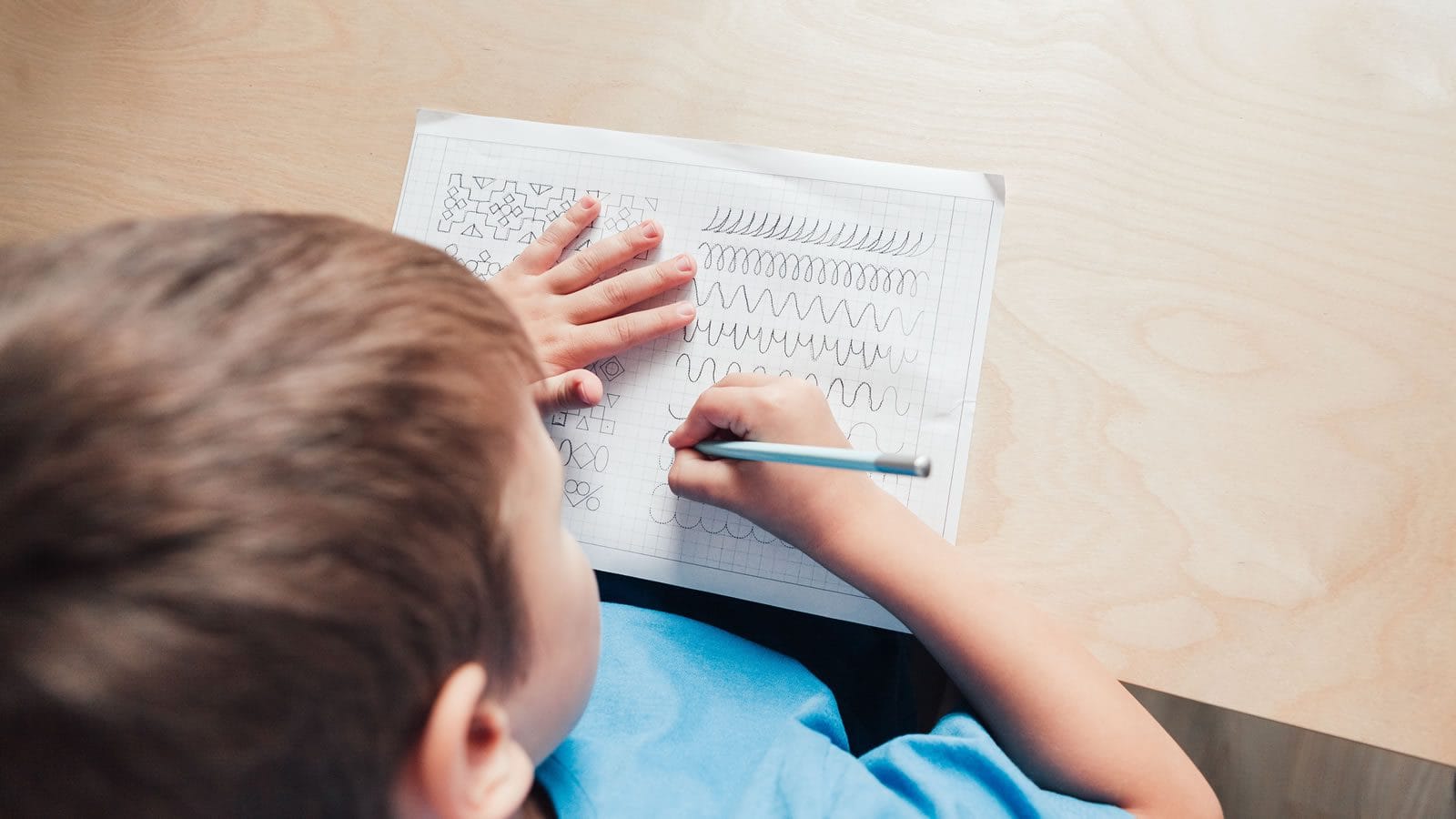 focused-child-practicing-drawing-skills-at-home focused child practicing drawing skills at home